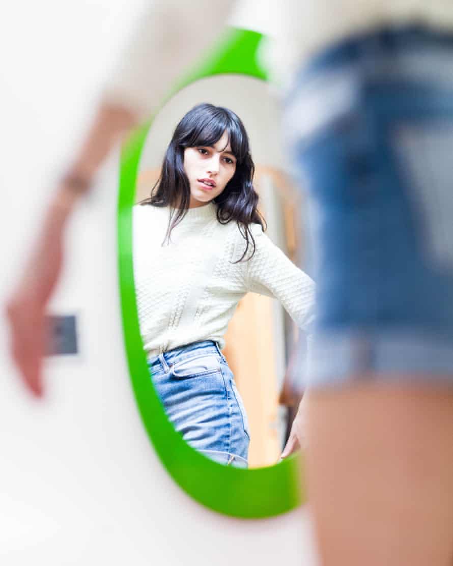 Young woman looking at herself in mirror