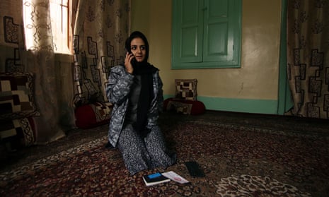 Kashmiri Pulitzer-winning photojournalist Sanna Irshad Mattoo listens to a phone as she sits in a room