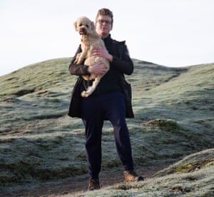 Walk James, holding his dog, at Cissbury Ring, South Downs