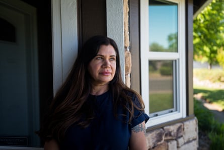 woman stands outside home and looks to side