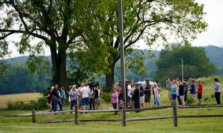 people and media gathered outside on grass