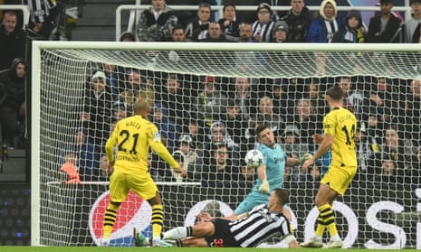 Newcastle keeper Nick Pope saves a shot from Donyell Malen of Borussia Dortmund (left).