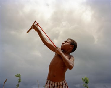 A boy with a slingshot aims into the air