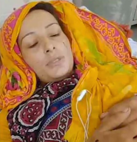 A young woman lying down with a yellow head covering