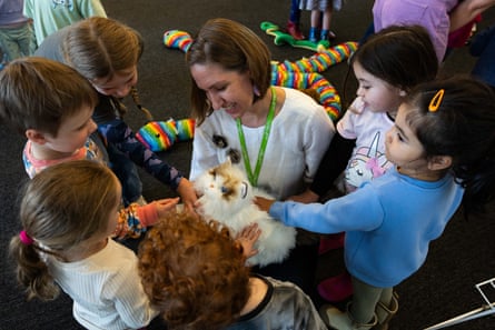 Storytime leader Elissa shows children the cats at Springwood library