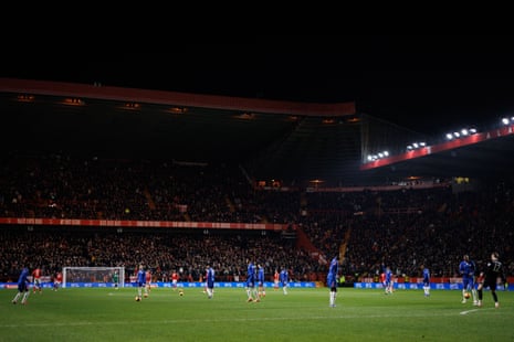 The players pass balls around as they try to keep warm as the game is paused for a medical emergency in the crowd.