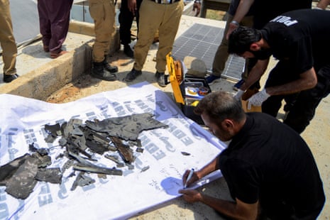 A member of the Crime Scene Unit (CSU), inspects the fragments of what is claimed to be an Indian drone brought down on the outskirts of Karachi, Pakistan 8 May.