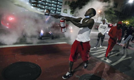 A man uses a fire extinguisher to protest the death of George Floyd, a handcuffed black man in police custody on Memorial Day in Minneapolis, Friday, May 29, 2020 in Indianapolis. The protest comes after a series of prominent black deaths that have inflamed racial tensions across the United States.(Jenna Watson/The Indianapolis Star via AP)