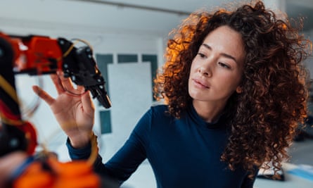 Engineer examining robotic arm in office