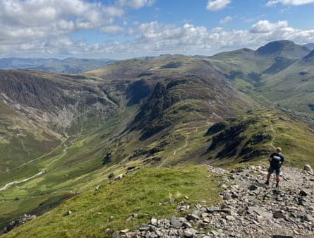 A walker takes in a view in the Lake District in good weather