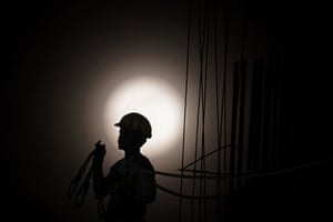 A construction worker is silhouetted against the full moon in Kolkata, India.