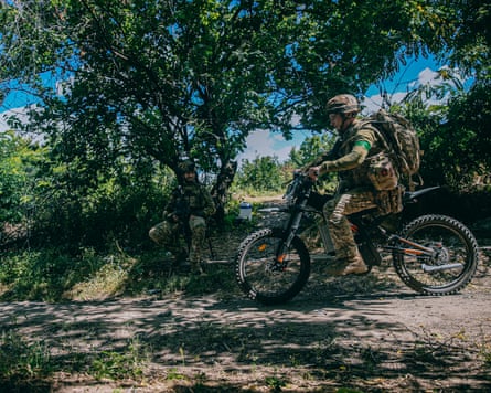 A soldier rides a scooter.
