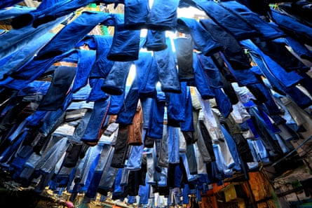 A hot looking upwards at hundreds of pairs of jeans hanging in an outside space.