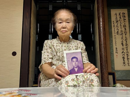 Yoshiko Niiyama holds a photo of her father
