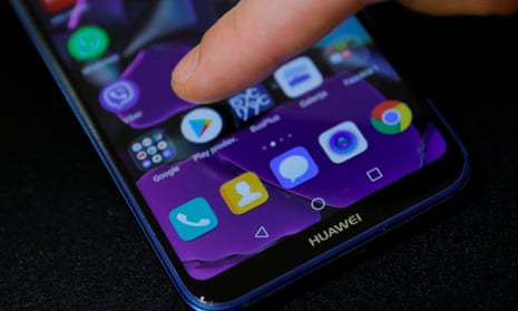 Man points a finger to the Google Play app logo on his Huawei smartphone