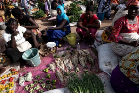 Fish and vegetable sellers wait for customers at Tanji fish market.