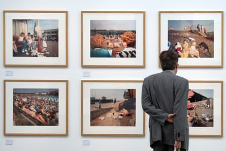 Man in suit looking at paintings on wall