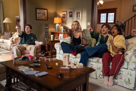 a group of people sitting on a couch and pointing