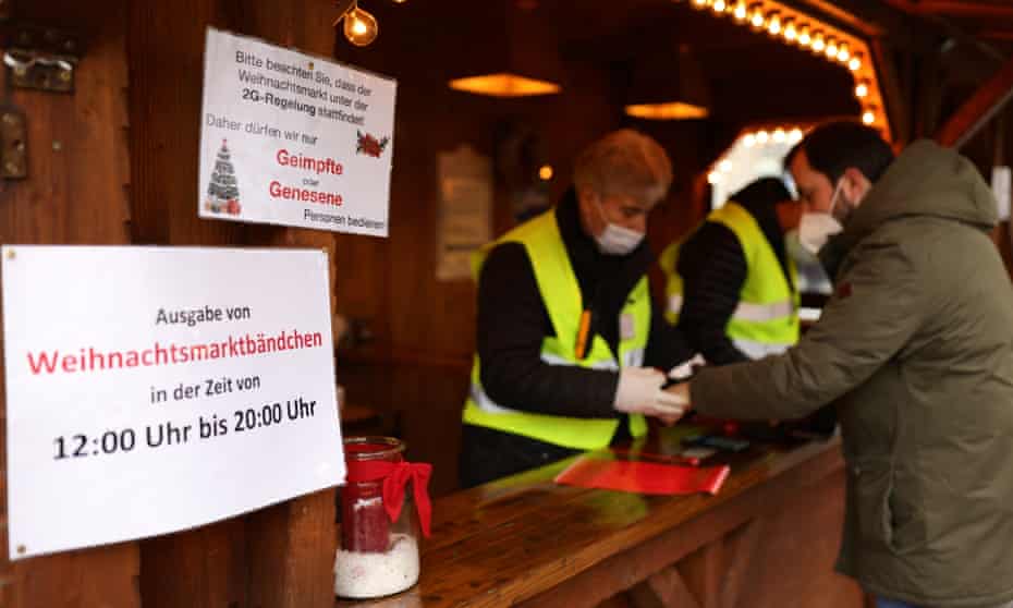 A man receives a wristband after having his vaccination status checked at a Christmas market in Bonn, Germany.