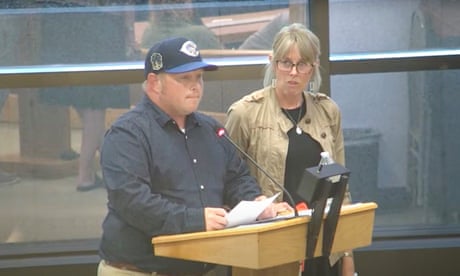 Man and woman at podium read from sheet of paper.