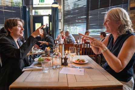 Margaret and Clare clink chat across a restaurant table