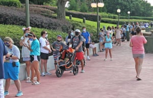 Guests wearing protective masks wait to pick up their tickets at the Magic Kingdom theme park at Walt Disney World on the first day of reopening, in Orlando, Florida, on 11 July, 2020.