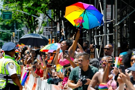 A celebrant waves a rainbow-colored umbrella as cheering crowds gather on Fifth Avenue at the 54th annual NYC Pride march on 25 June.
