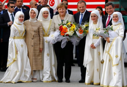 German chancellor Angela Merkel, EU council president Donald Tusk and Turkish prime minister Ahmet Davutoglu pose with refugees in traditional costume.