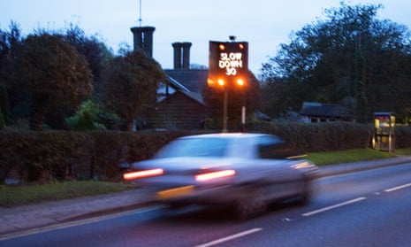 Car speeding past a slow down sign