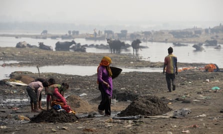 People work on the banks of Ramganga river as they collect scrap metal left as waste by brass factories in Moradabad.