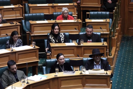 Lawmakers sit behind wooden tables.