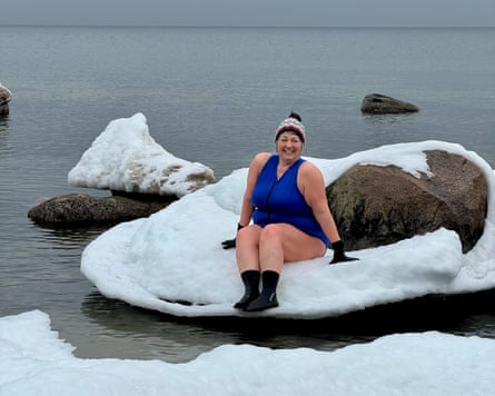Ella Foote sitting on an icy rock in a cold sea
