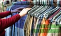 A man chooses secondhand clothes at a flea market