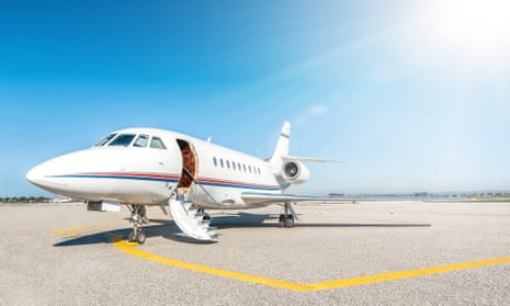 A private jet on a runway under a blue sky.