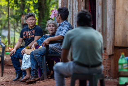 Empat orang duduk di luar sebuah rumah kayu.
