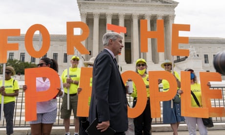 Sen. Sheldon Whitehouse, D-R.I., walks past people holding up the words "For the People" as he arrives for a rally in front of the Supreme Court, June 2021.