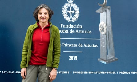 Sandra Myrna Diaz stands in front of a blue board advertising the Princess de Asturias awards.