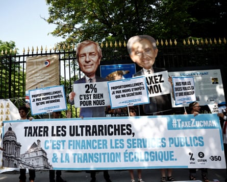 ‘Taxing the ultra-rich means financing public services and the ecological transition’; people hold placards depicting French billionaires with messages including ‘tax me’, ‘2% is nothing for us’ and ‘proportionally I pay less tax than a nurse’.