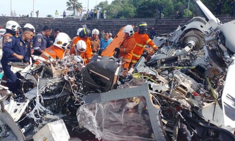 Rescue services inspect the crash site of two helicopters in Lumur, Perak state