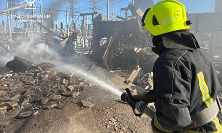 A firefighter works to put out a fire at energy facilities damaged by a Russian strike in Kyiv region.
