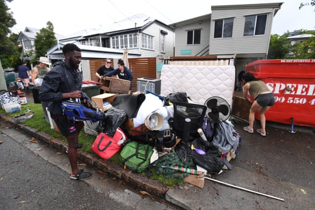 People are seen disposing of their flood damaged belongings in the suburb of Albion in Brisbane