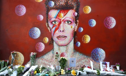Flowers lie in front of a mural tribute to Bowie in Brixton, London, after his death in January 2016.