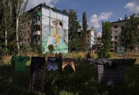 Clothes hanging out to dry on a washing line amid partially decomposing tower blocks.