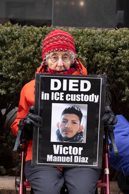 a women holding a photo that reads ‘DIED in ICE custody Victor Manuel Diaz’