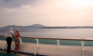 An older couple on a cruise ship looking out to sea