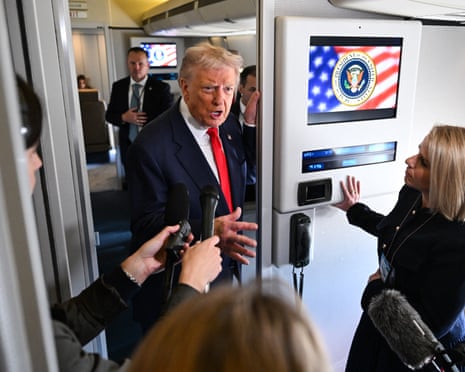 man in suit speaks into microphones on plane