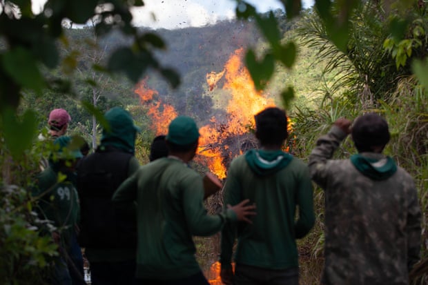 Guajajara activists watch as a tractor used by illegal loggers is torched during their operation in the Araribóia indigenous territory