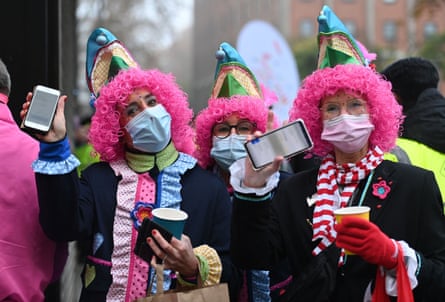 Revellers show their mobile phones displaying their vaccination certificates at the start of the carnival season in Cologne, western Germany, on 11 November.