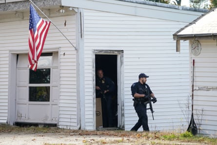 Members of law enforcement search a farm in Lisbon Falls, Maine on Friday.
