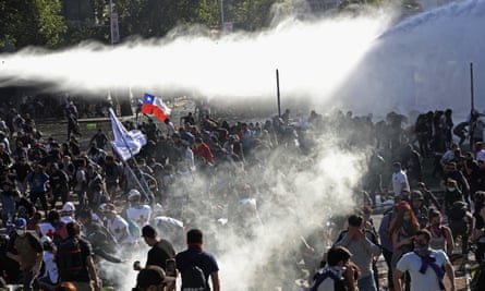 Demonstrators run from police firing water cannon and teargas in Santiago